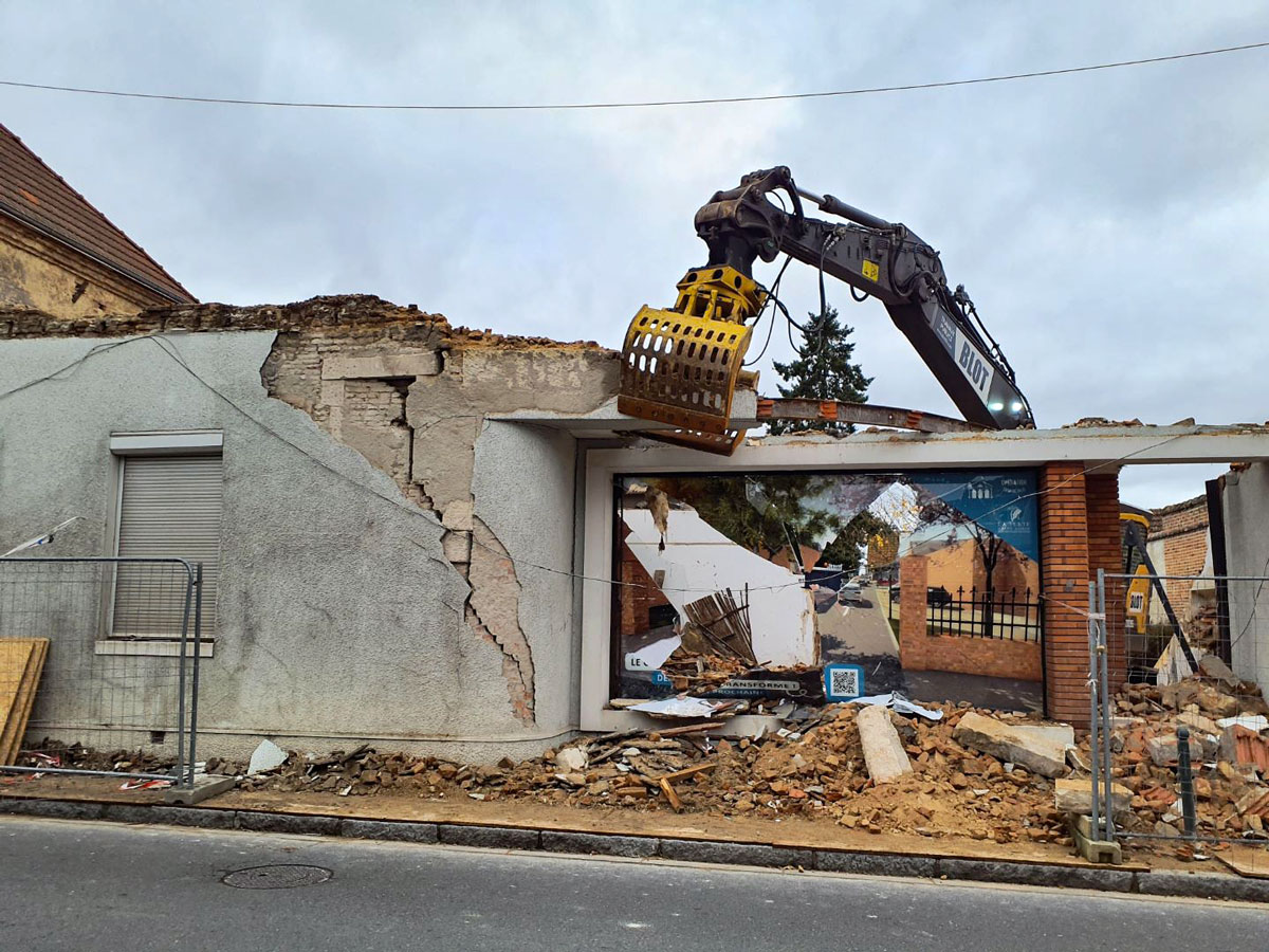 Pelle mécanique BLOT intervenant sur le bâtiment en cours de démolition