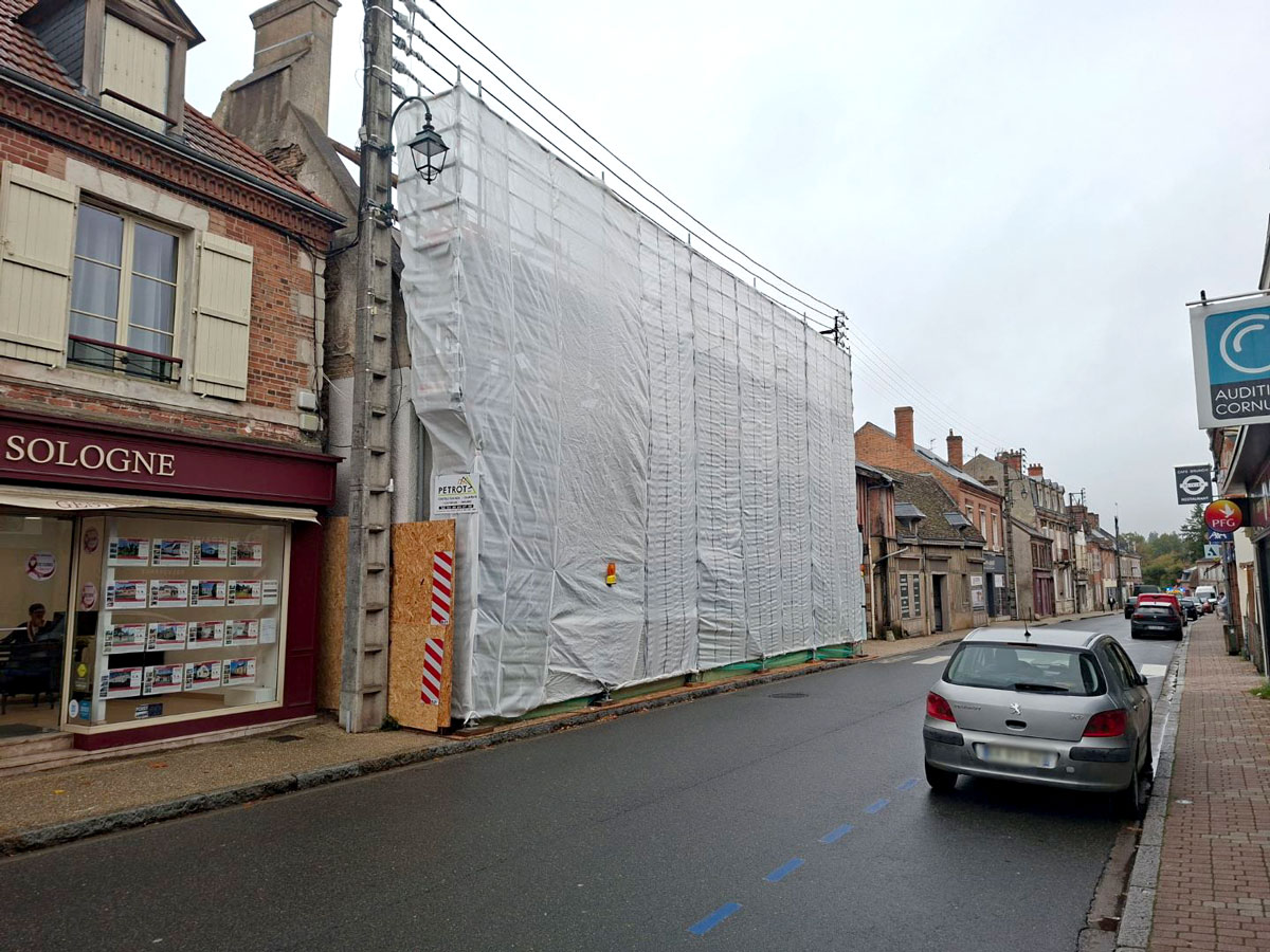 Échafaudage de protection installé avant la démolition d’un bâtiment en centre-ville de La Ferté-Saint-Aubin